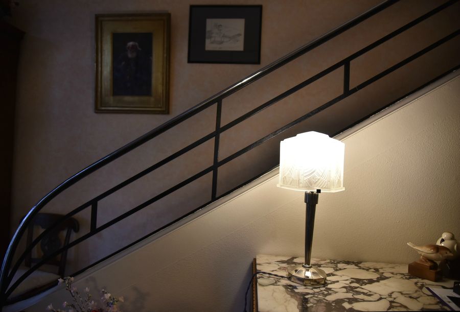 Une lampe de style Art déco pour éclairer une montée d’escalier avec rampe tubulaire courante à cette époque.