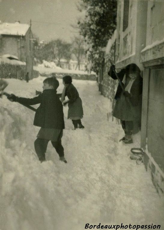 En 1956, devant le 30 rue de Canolle, la famille Sabatié dégage le trottoir enneigé. Au loin le mur du domaine Pellegrin et la maison du concierge. (Photo Marie-France Sabatié)