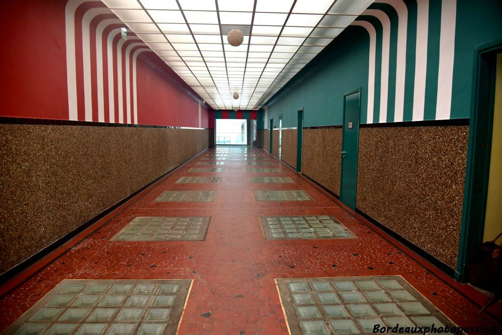 Galerie d'accès moderniste où la lumonisité du plafond met en valeur les couleurs choisies par l'architecte.