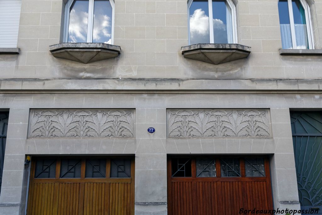 Les 2 garages au centre de cette façade symétrique sont décorés de frises de fleurs en méplat. Ils sont les symboles d'une nouvelle modernité.
