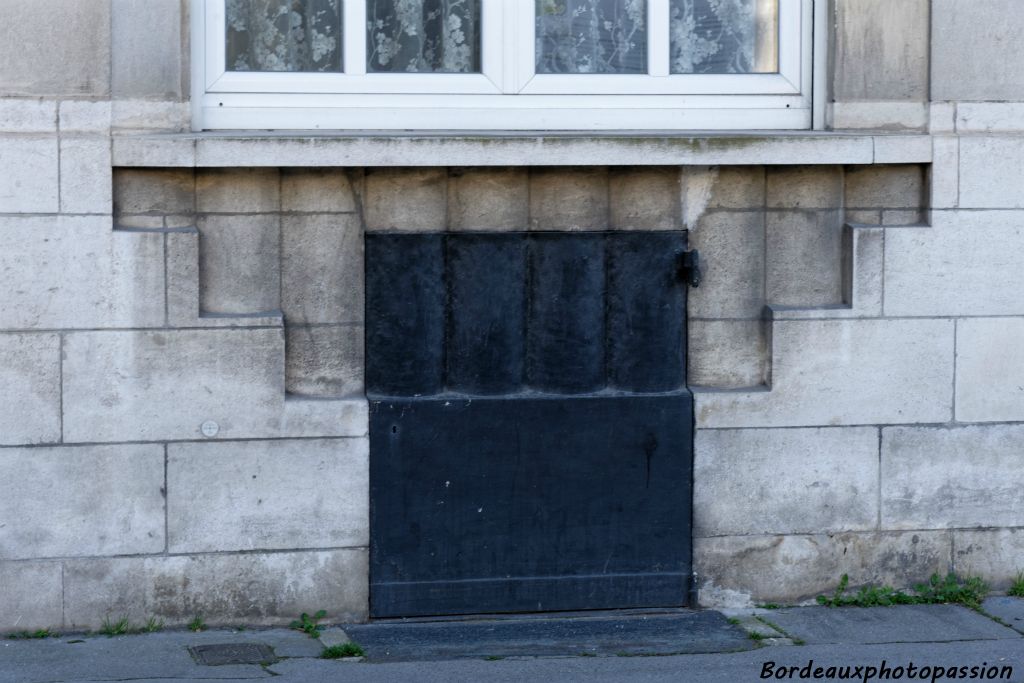 Une porte à charbon épousant parfaitement la décoration géométrique de la pierre, ce qui est exceptionnel à Bordeaux.
