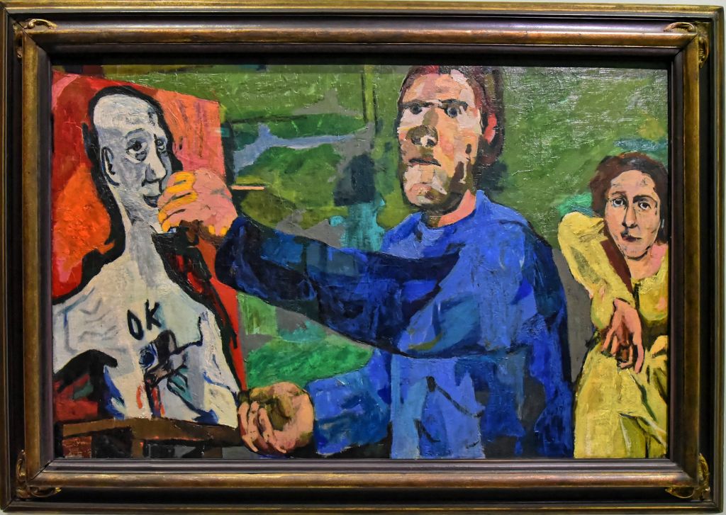Le peintre et son modèle II Kokoschka est en train de se peindre le crâne rasé. C'est un double autoportait observé par une femme en jaune à l'arrière.