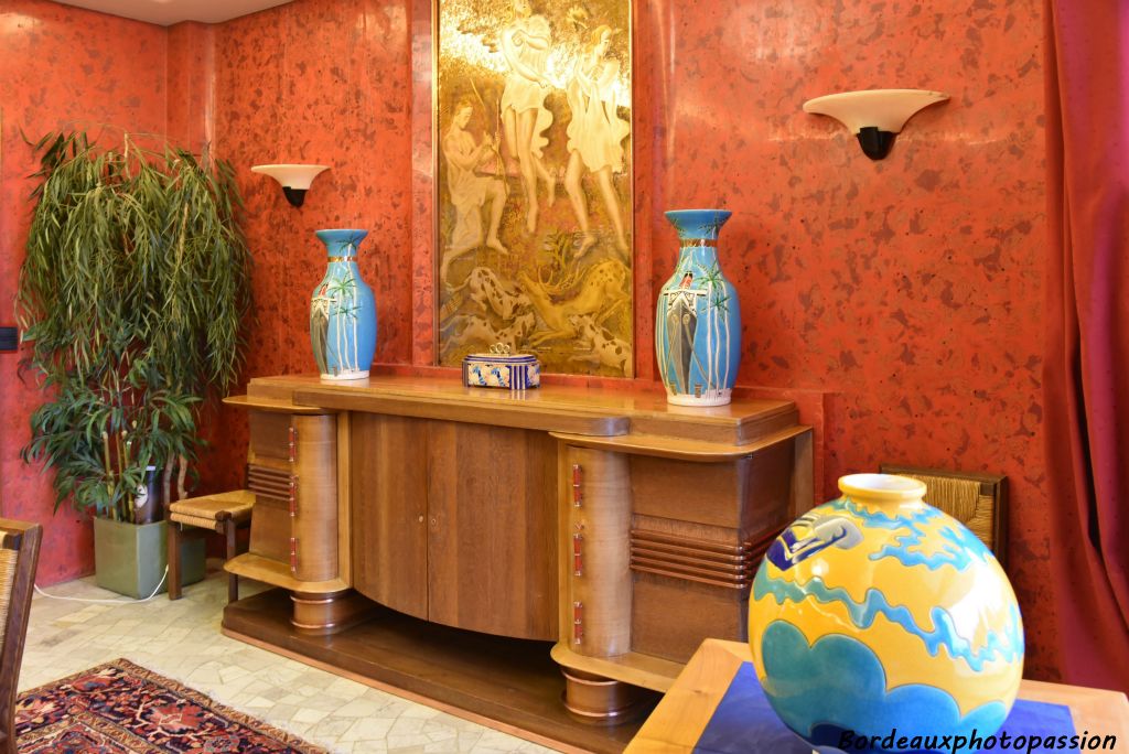 Un ensemble décoratif cohérent des années 30 : le meuble est de Pierre Petit. Il est en chêne et merisier et décoré de barres en bronze.  Avec une boule coloniale au premier plan.