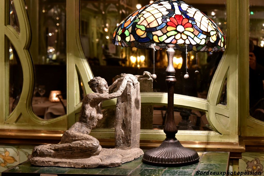 Une sculpture éclairée par une lampe de style Tiffany, du nom peintre et verrier américain Louis Comfort Tiffany.